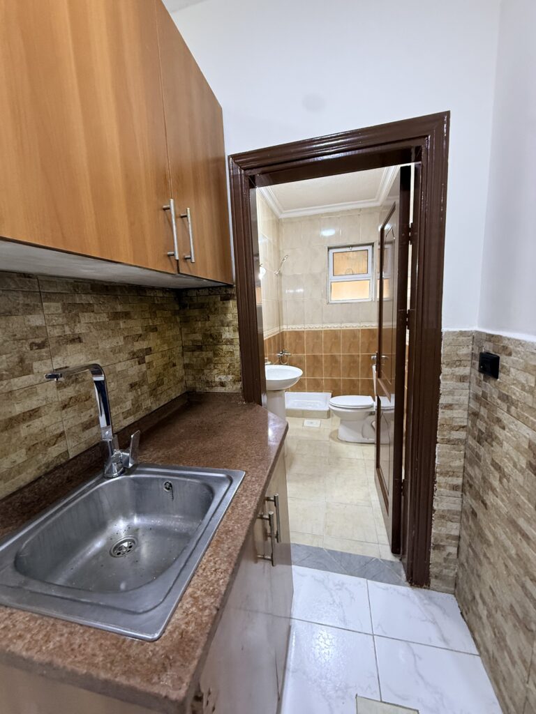 Hallway with wooden doors and tiled flooring in Apartment D-101