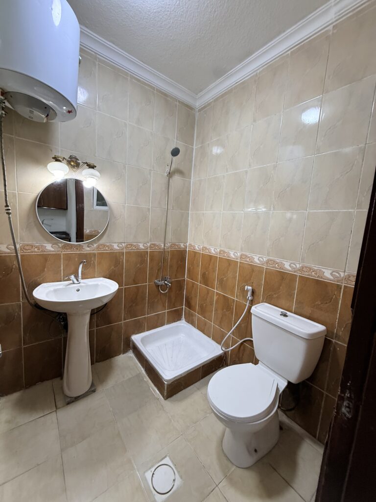 Hallway interior of Apartment D-101 with wooden doors and tiled flooring